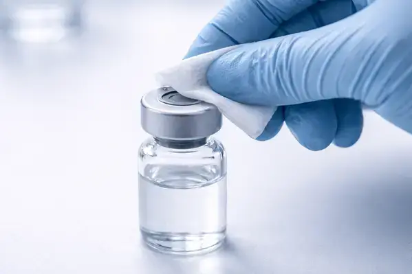 Researcher sanitizing a bacteriostatic water vial stopper with an alcohol swab before peptide reconstitution