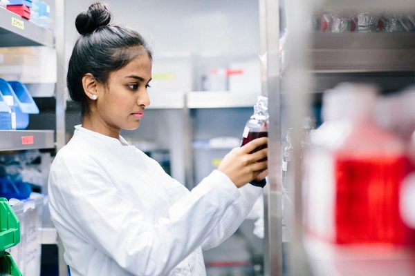 Scientist inspecting NAD+ samples in a temperature-controlled laboratory storage unit